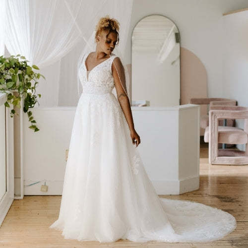 Bride wears lace wedding dress as she glances back at her train